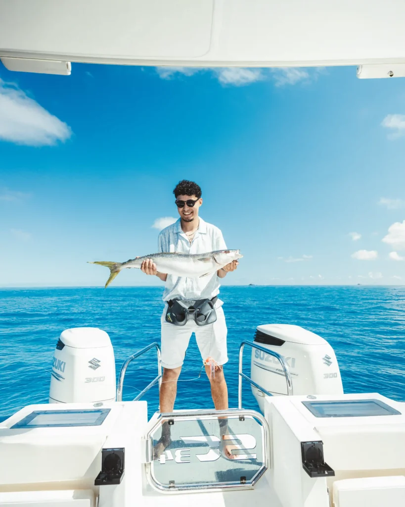 man-holding-fresh-catch-on-yacht-deck